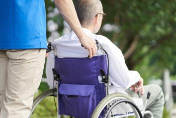 Caregiver supporting the elderly in wheelchairs Caregiver supporting the elderly in wheelchairs